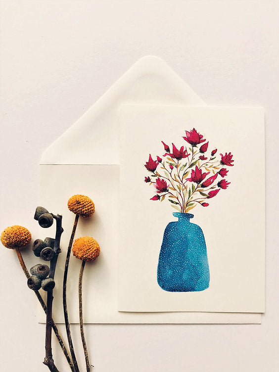 “Blue vase with magnolia flowers arranged in a delicate and artistic style by Maria Zvaric. Handcrafted floral art perfect for home décor.”